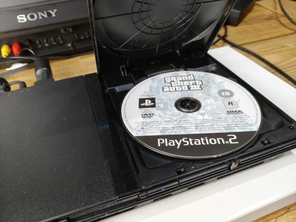 płyta z grą GTA3 umieszczona w napędzie konsoli Playstation 2 slim