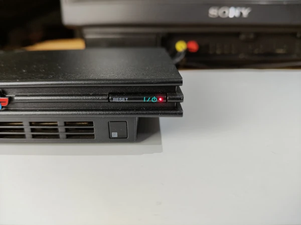 przycisk zasilania konsoli playstation 2 slim, z czerwoną diodą czuwania